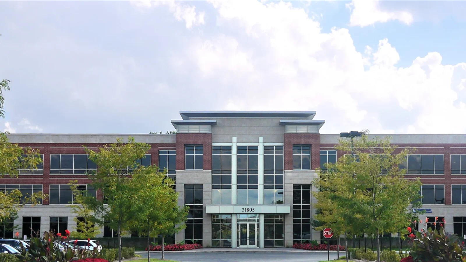 21805 Field Parkway Office, a three-story brick and renaissance stone building with a glazed stone entry tower under a flat projecting canopy.