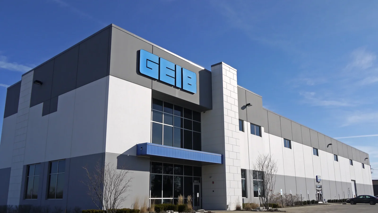 340 County Line Road's Geib tenant corner, with a two-story glazed entry, blue canopy and grey-and-white precast panels under a clear sky.