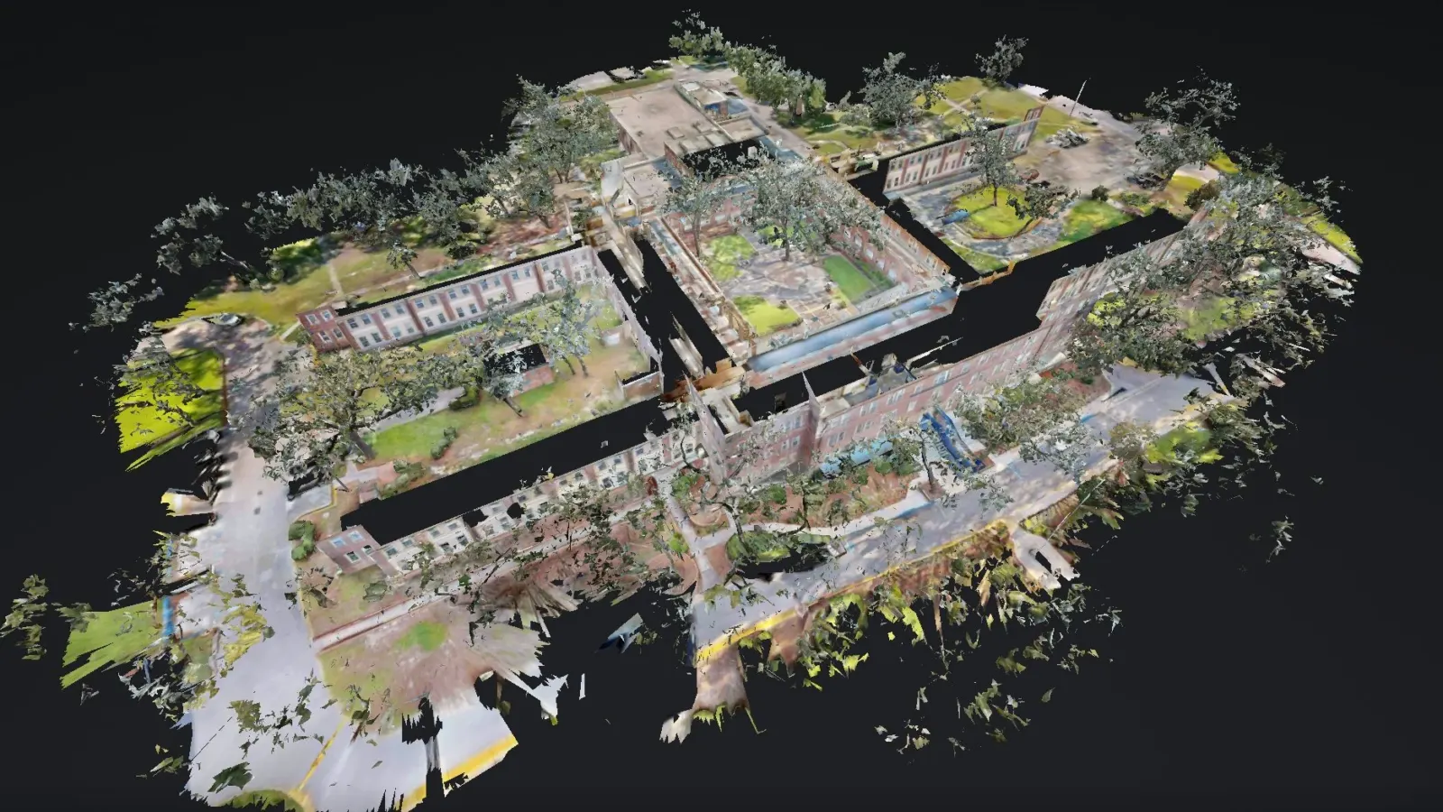 Dollhouse view of a 3D scan of a brick building at NAS Pensacola, its wings and tree-shaded courtyards captured as one model.