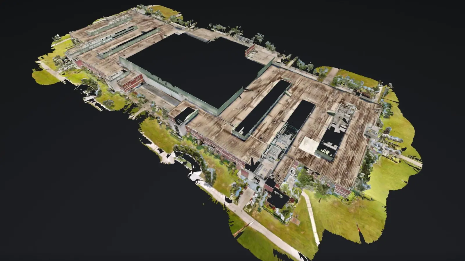 Dollhouse view of a 3D scan of a large multi-wing training center at NAS Pensacola, seen from above with its roofs and surrounding lawns.