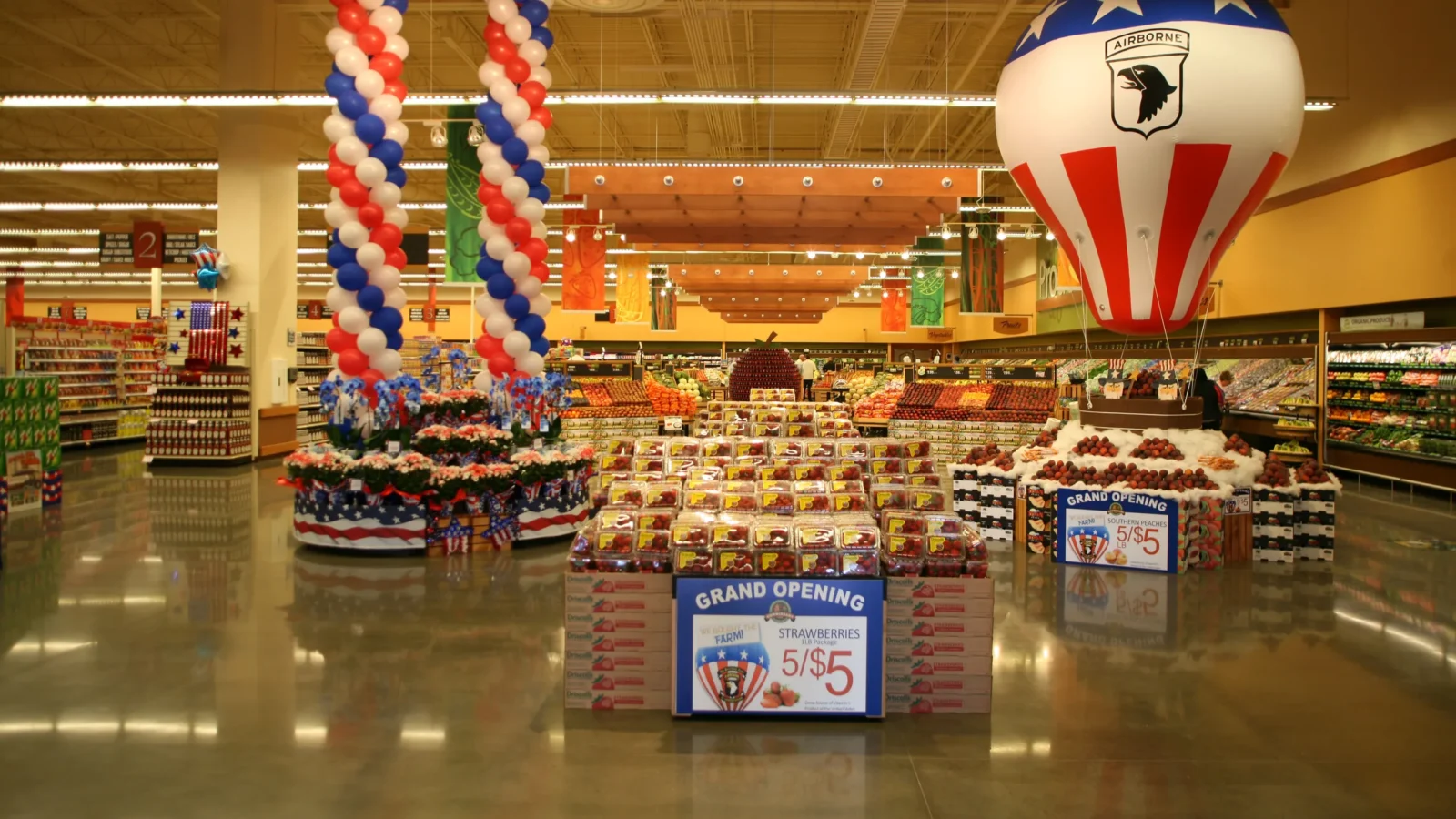 Main sales floor decorated for the grand opening, with strawberry and peach displays, a 101st Airborne balloon and polished concrete floors.