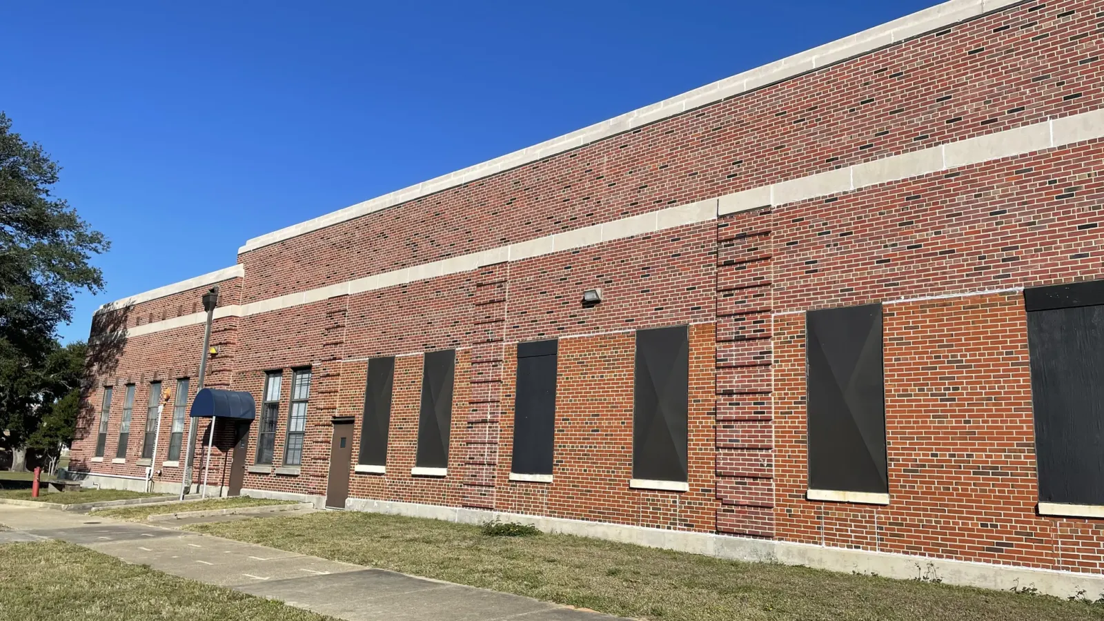 The same 1941 training building before its Package 7A repairs, with its storm-damaged window openings boarded over.