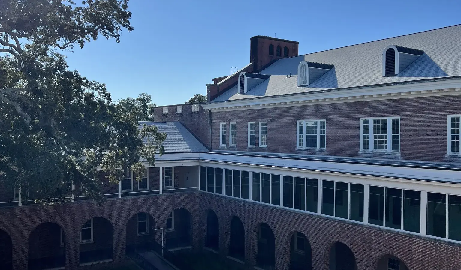 The courtyard of the early-1940s NETC administration building at NAS Pensacola, with its dormered roof and arched brick arcade.