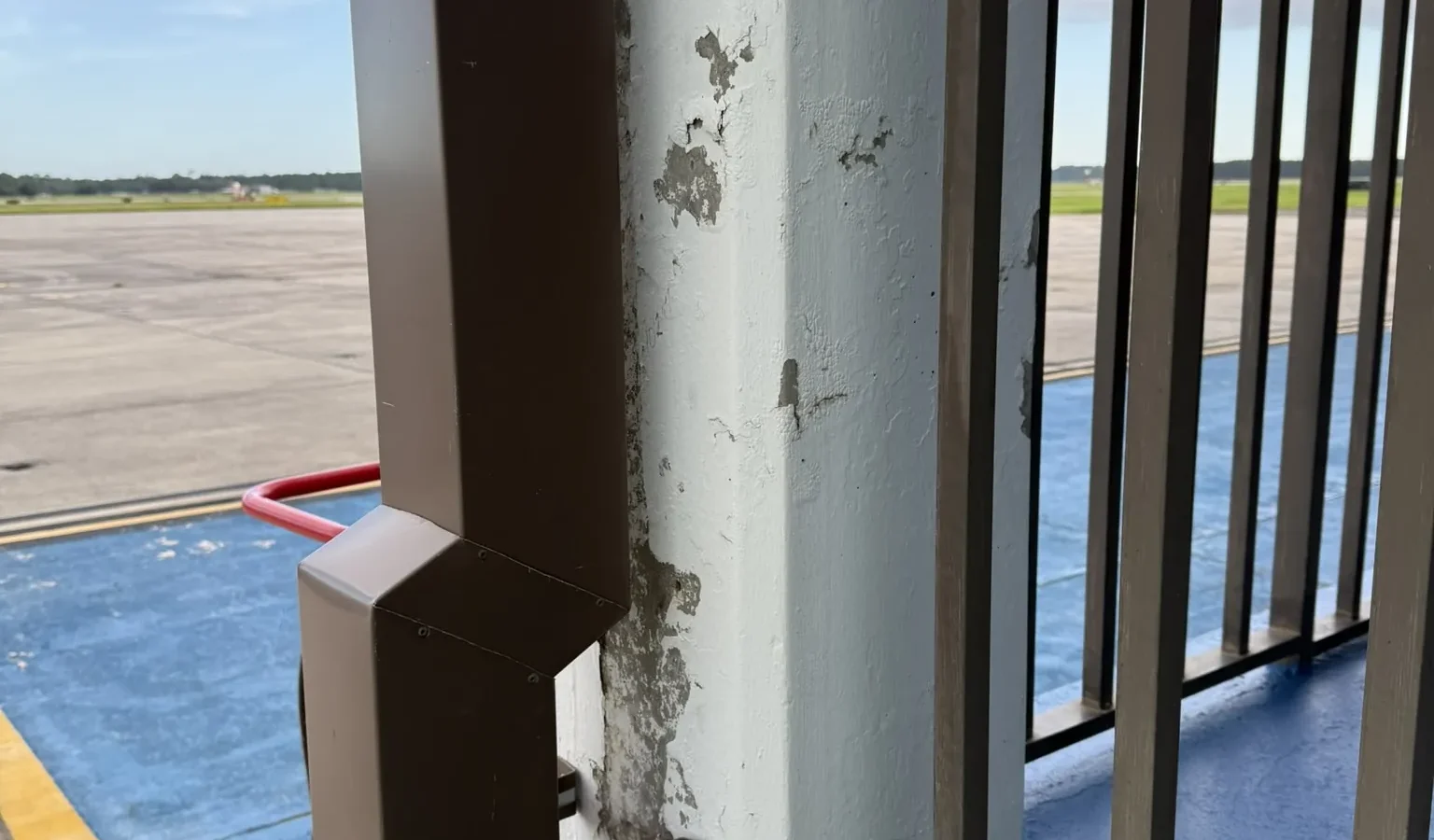 A balcony column and railing at the NAS Pensacola Air Operations Building, looking out over the airfield.