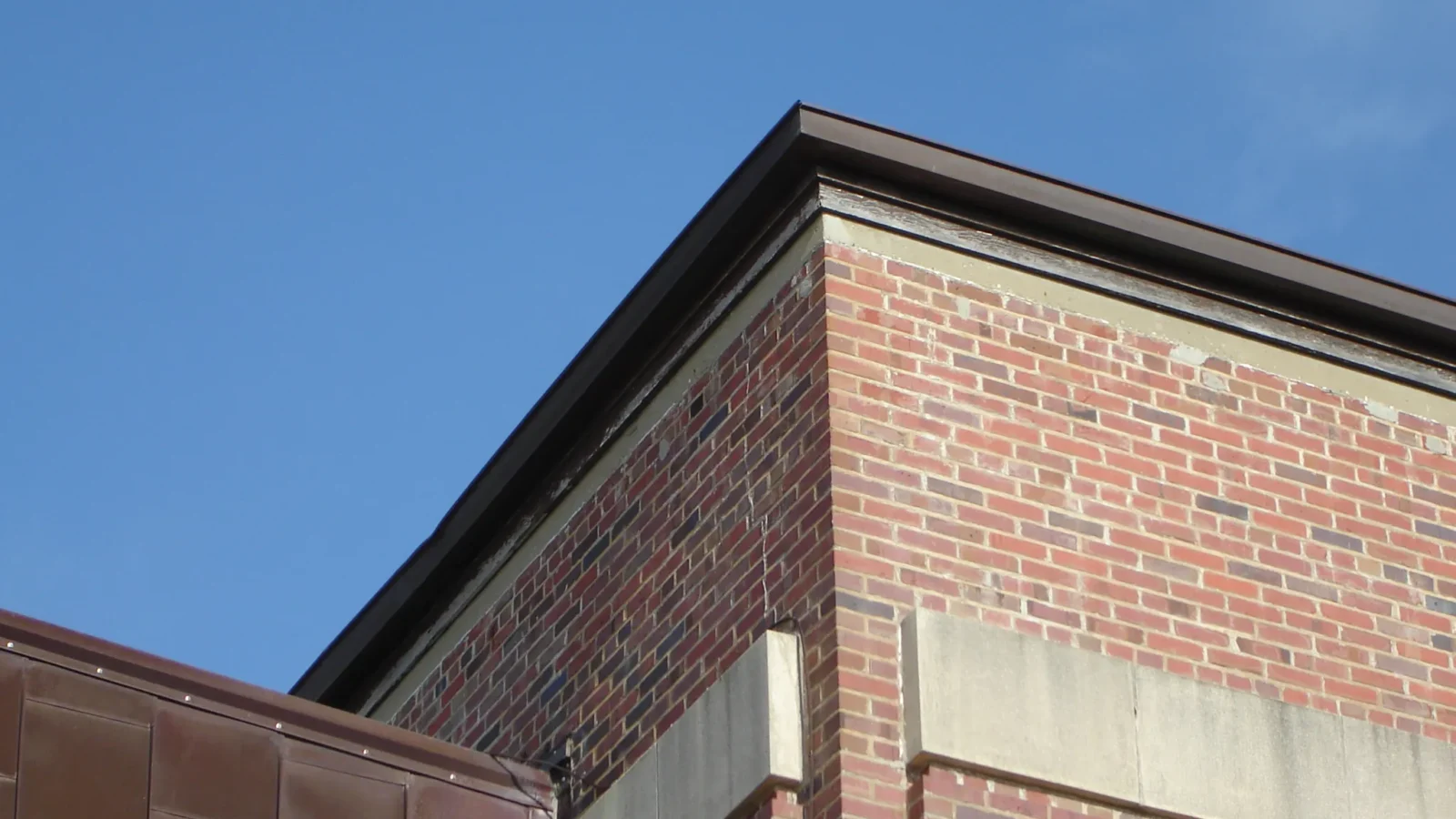 The brick corner tower and parapet of Gunn Hall at Corry Station, an instructional building originally built as a hangar.